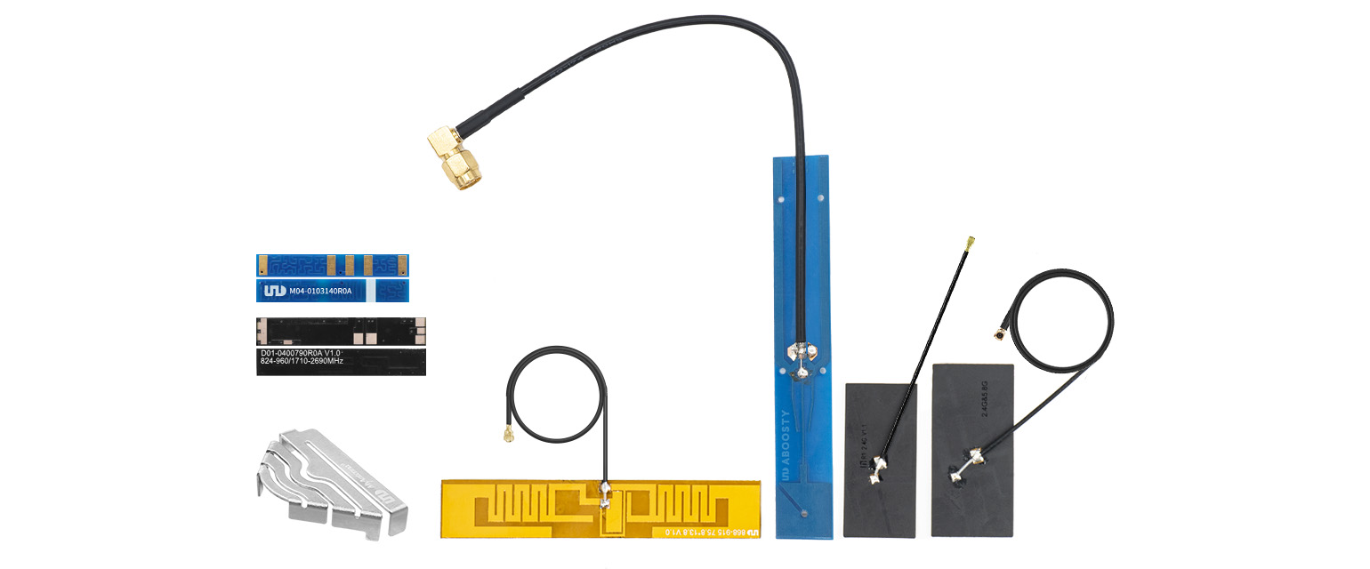 An assortment of antennas and RF components, including dipole antennas, a PCB antenna, coaxial cables, and connectors